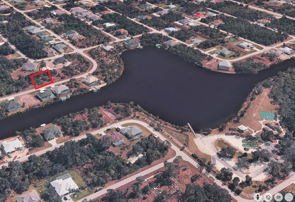 An aerial view shows a vacant residential lot outlined in red near a large lake — 10126 BOYLSTON STREET, PORT CHARLOTTE, FL