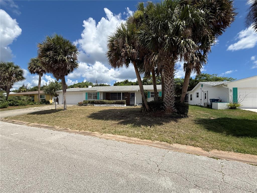 A single-story house with a white exterior, turquoise shutters, and several palm trees in front — 27 KATHY DRIVE, ORMOND BEACH, FL