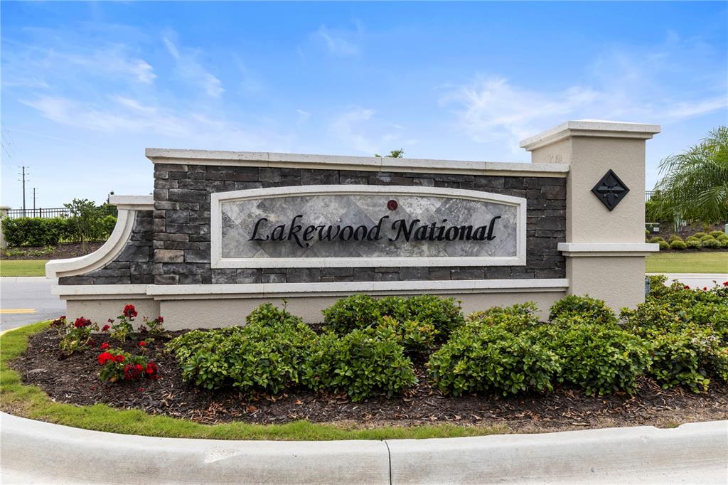 A stone and stucco monument sign for Lakewood National stands in a landscaped garden bed — 18008 GAWTHROP DRIVE UNIT 402, LAKEWOOD RANCH, FL