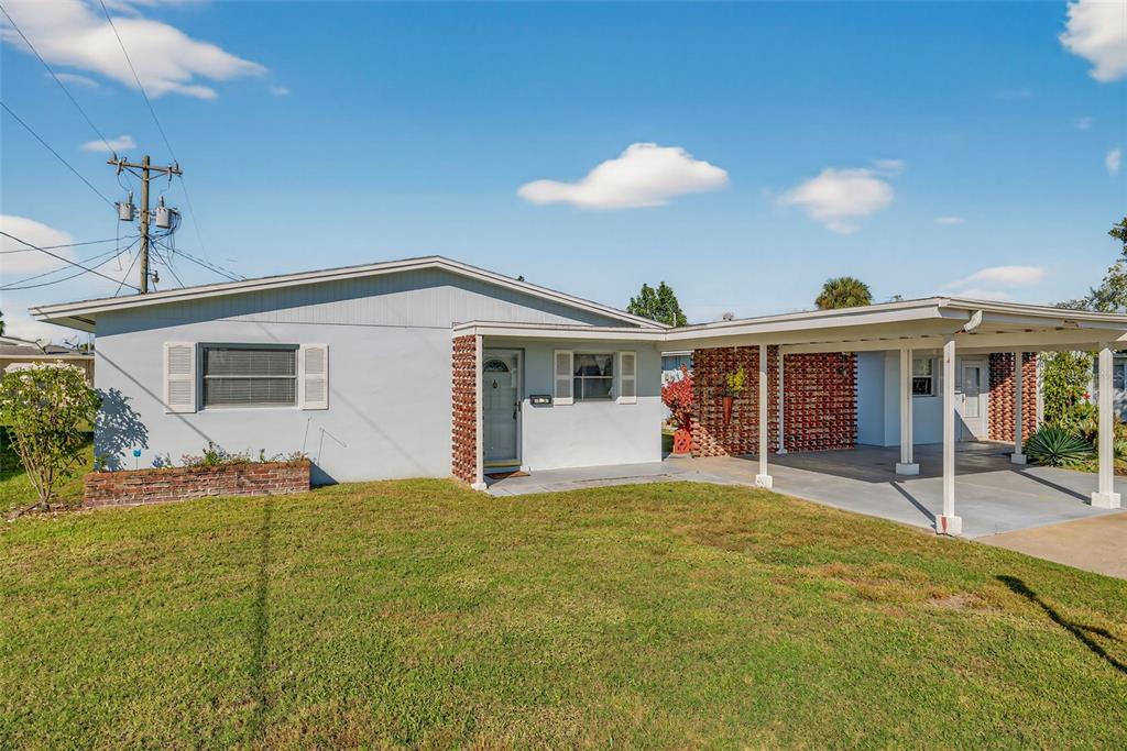 A light blue single-story house features a brick planter and an attached carport — 2207 CROTON COURT UNIT 0, LEHIGH ACRES, FL