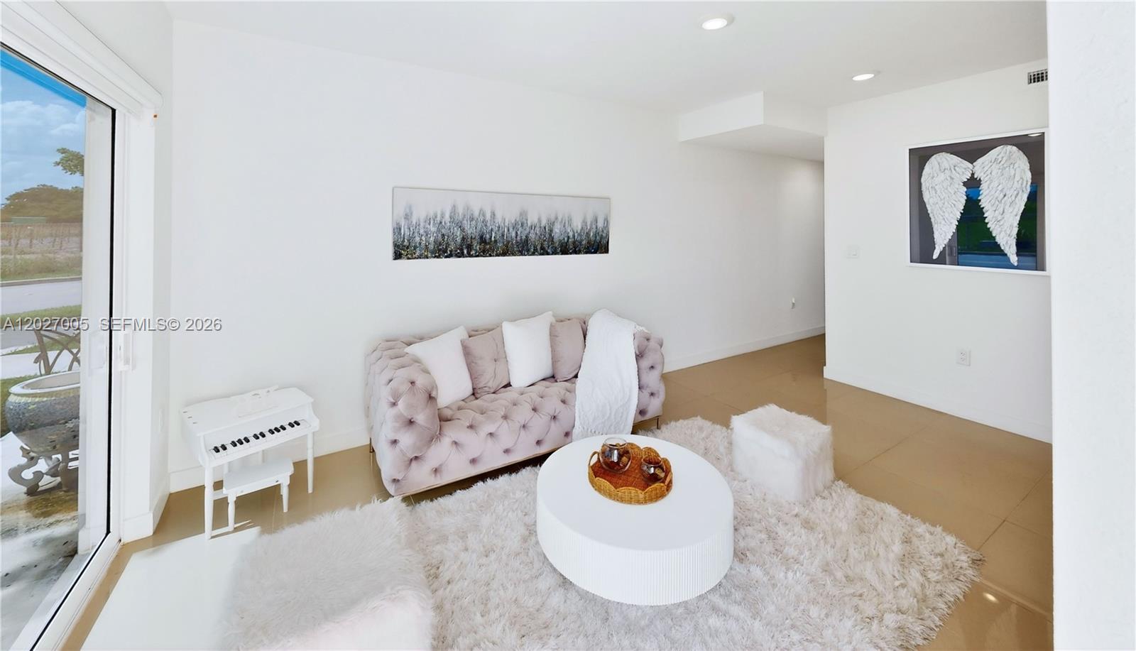 A living room features a tufted sofa, white circular coffee table, and a small piano — 25813 SW 145th Ave, Homestead FL 33032, HOMESTEAD, FL