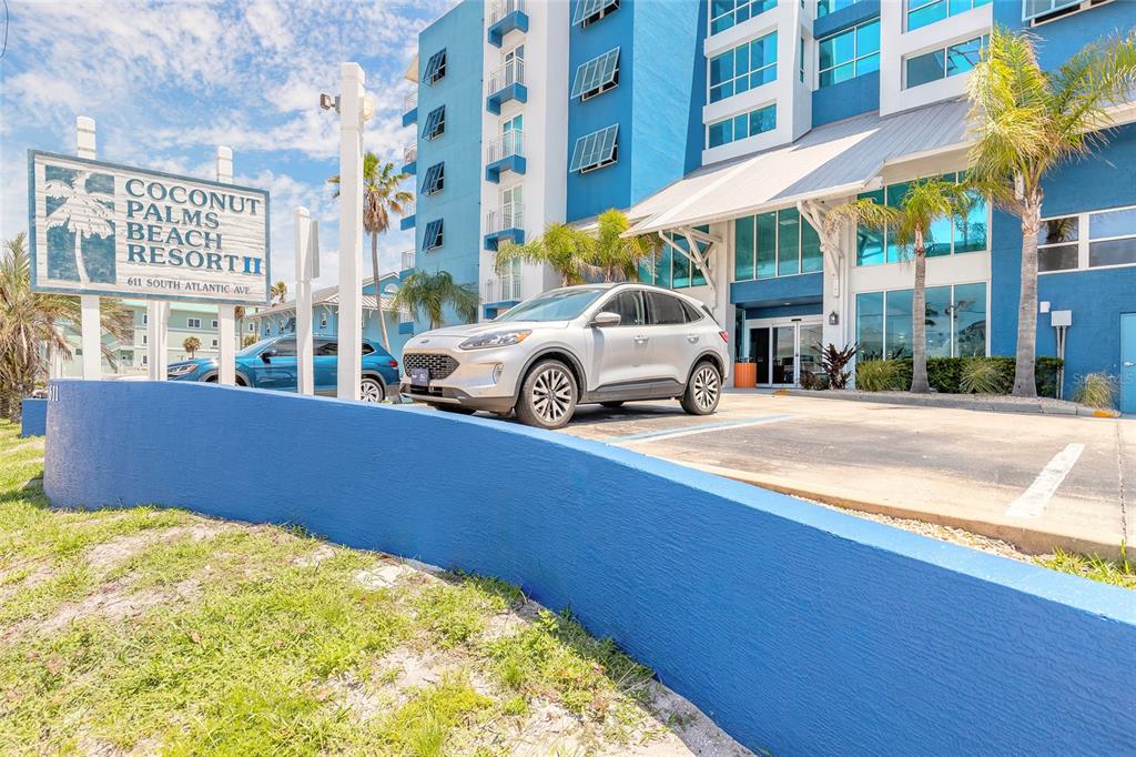 A silver SUV is parked in front of the blue Coconut Palms Beach Resort building — 611 S ATLANTIC AVENUE UNIT 4312, NEW SMYRNA BEACH, FL