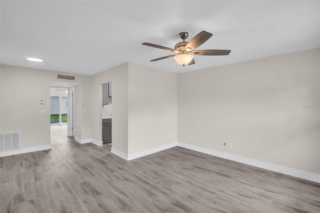 An empty room with light-colored walls, gray wood-look flooring, and a ceiling fan — 24862 US HIGHWAY 19 N UNIT 1105, CLEARWATER, FL