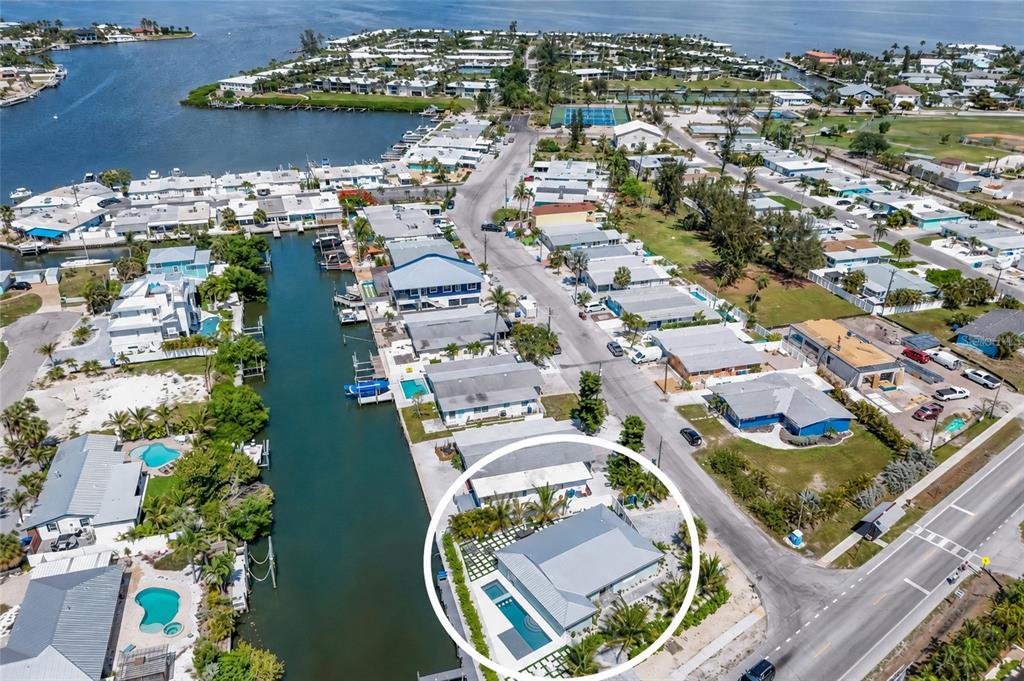 An aerial view shows a waterfront house with a private pool and dock — 6401 MARINA DRIVE, HOLMES BEACH, FL