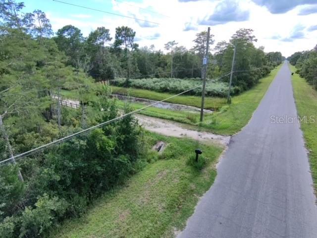 An aerial view shows a paved road running alongside a grassy area and a drainage ditch — SHELDON STREET, ORLANDO, FL