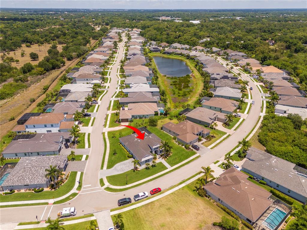 An aerial view shows a suburban neighborhood with houses, a central pond, and streets — 7181 RYEDALE COURT, SARASOTA, FL
