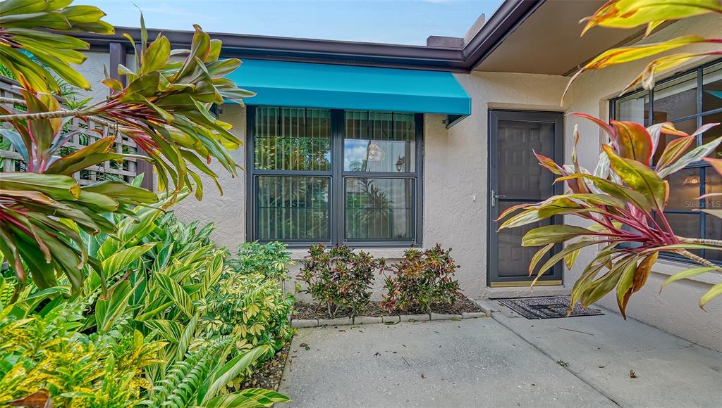 A tan, single-story residential building features two garage doors and a concrete driveway — 5956 CLUBSIDE DRIVE UNIT 7651, SARASOTA, FL