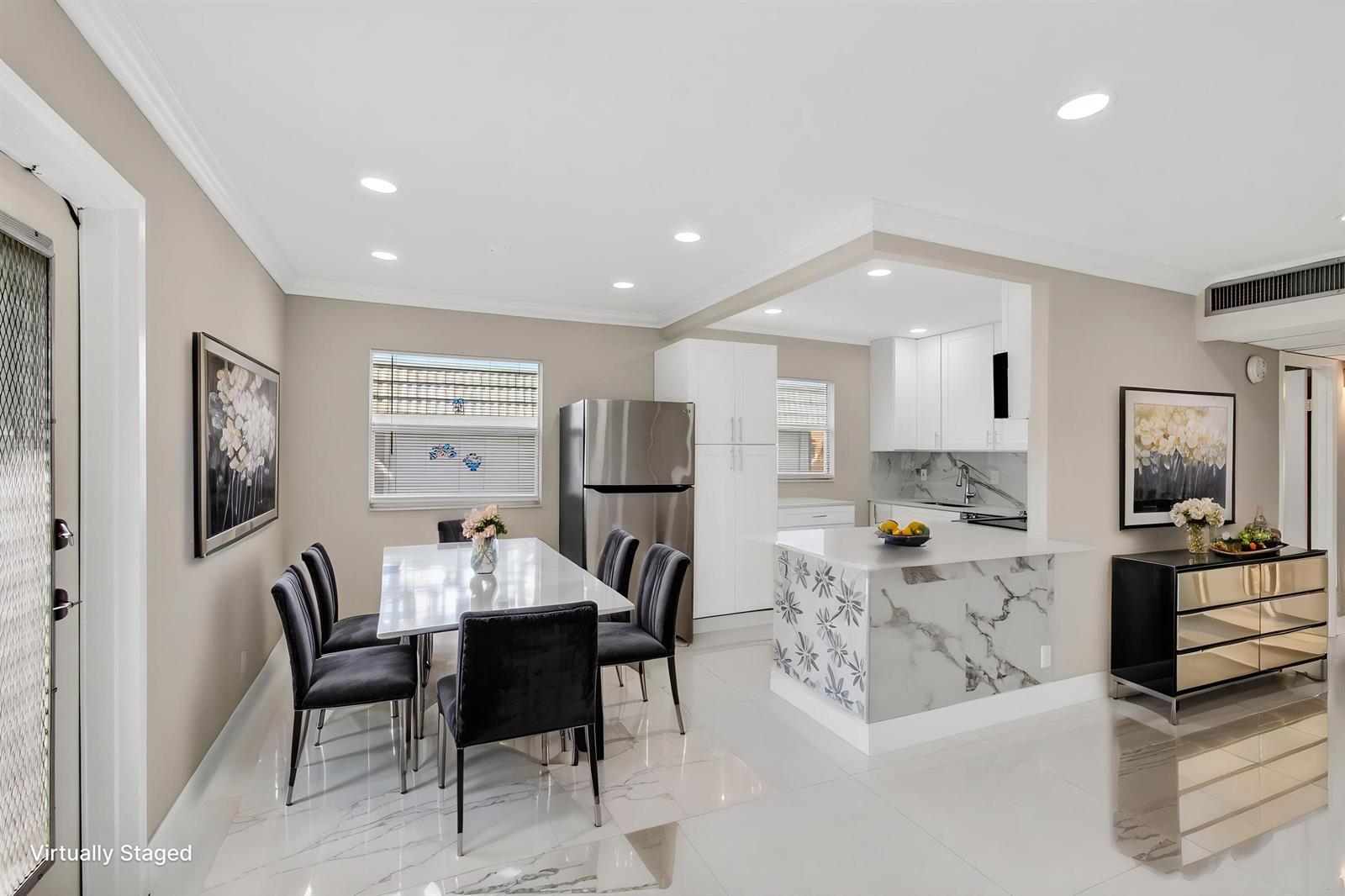 A dining area and kitchen feature white marble-look flooring, stainless steel appliances, and modern furniture — 429 Flanders I, Delray Beach FL 33484, DELRAY BEACH, FL