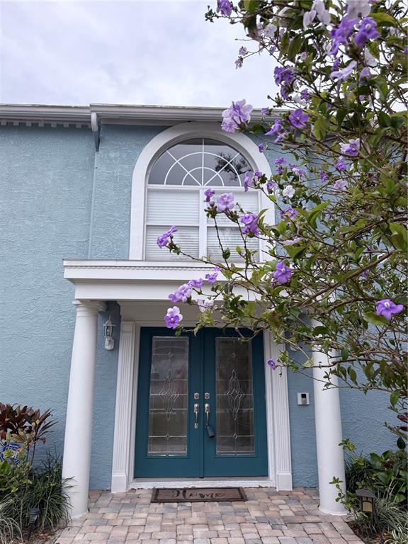 A blue house exterior features a double front door, white columns, and a large arched window — 13548 LAKE MAGDALENE DRIVE, TAMPA, FL