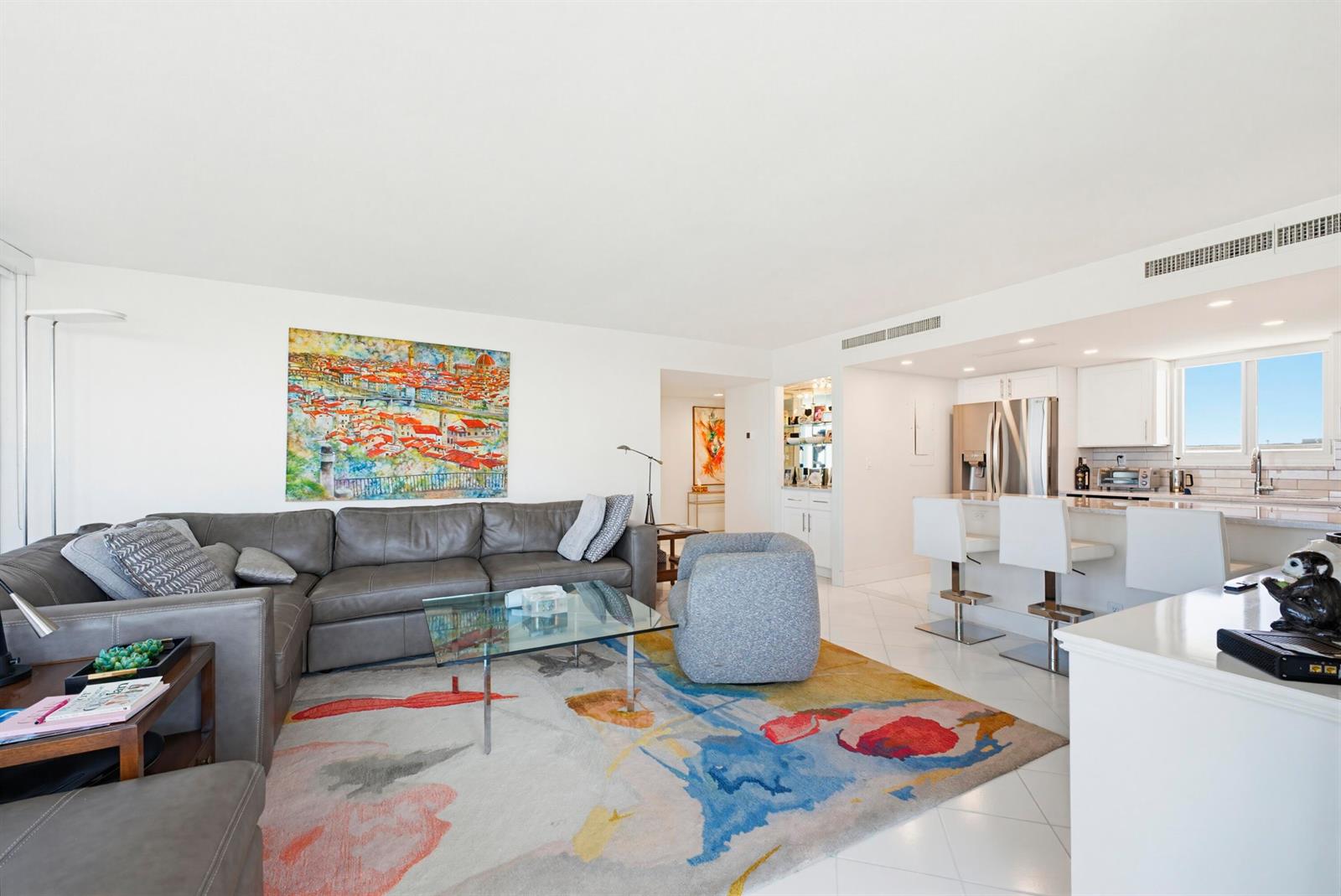 A living room with a grey sectional sofa, glass coffee table, and colorful area rug — 2505 S Ocean Boulevard, Palm Beach FL 33480, PALM BEACH, FL