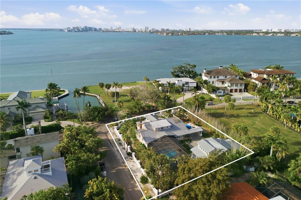An aerial view shows a waterfront house with a pool and a screened-in patio — 604 NORSOTA WAY, SARASOTA, FL