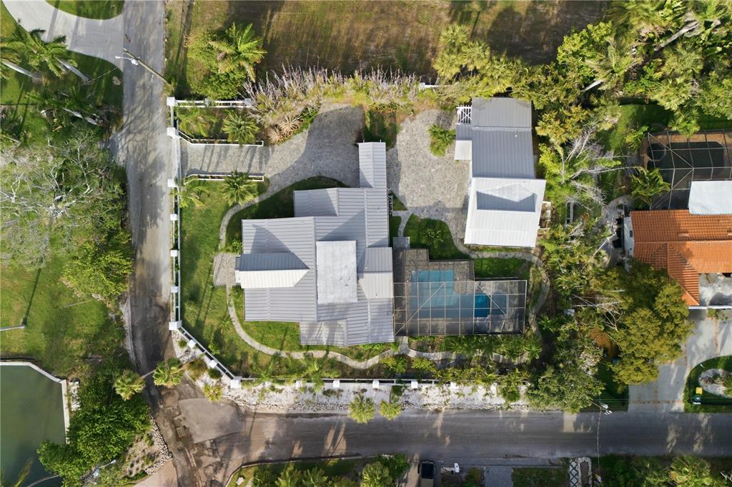 An aerial view shows a house with a metal roof, pool, and detached garage — 604 NORSOTA WAY, SARASOTA, FL