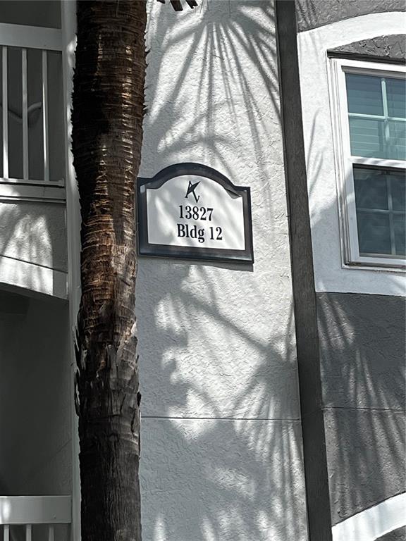 A building exterior sign displays the number 13827 and identifies it as Building 12 — 13827 FAIRWAY ISLAND DRIVE UNIT 1228, ORLANDO, FL