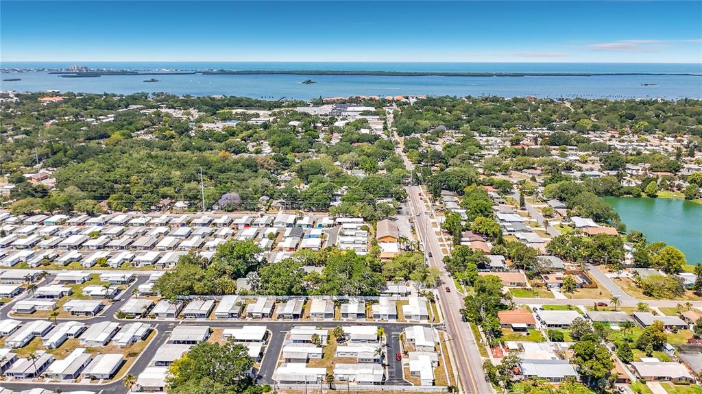 An aerial view shows a residential neighborhood with mobile homes and a nearby lake — 1040 MAIN STREET UNIT 162, DUNEDIN, FL