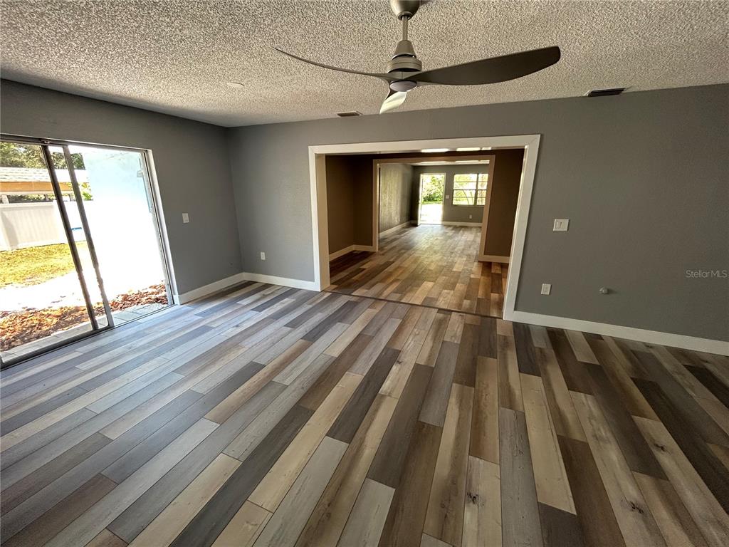 An interior view of a room with wood-look flooring, gray walls, and a ceiling fan — 5708 27 TH AVENUE S, GULFPORT, FL