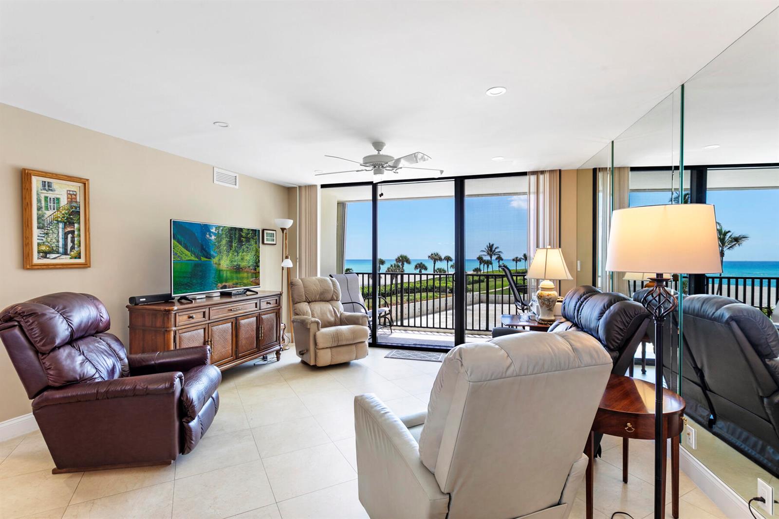 A living room with leather recliners, a television console, and a balcony overlooking the ocean — 400 Ocean Trail Way # 303, Jupiter FL 33477, JUPITER, FL