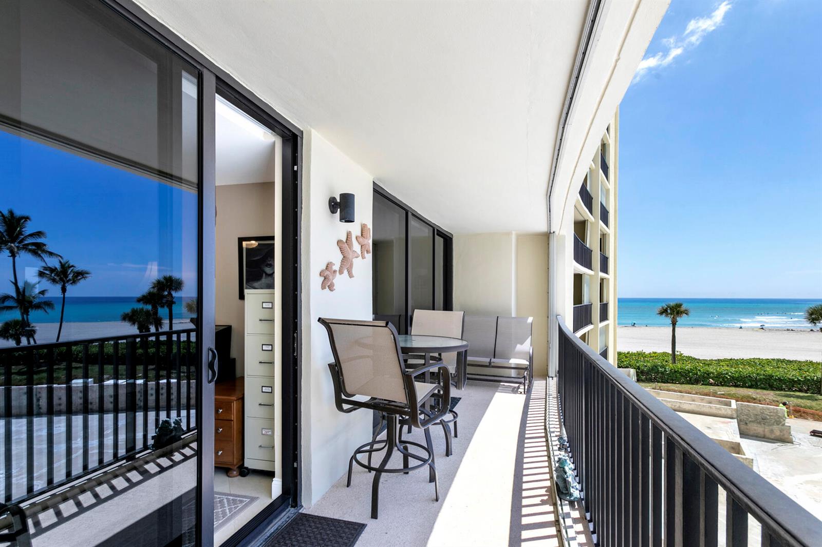 A balcony with outdoor furniture overlooks a sandy beach and the ocean — 400 Ocean Trail Way # 303, Jupiter FL 33477, JUPITER, FL