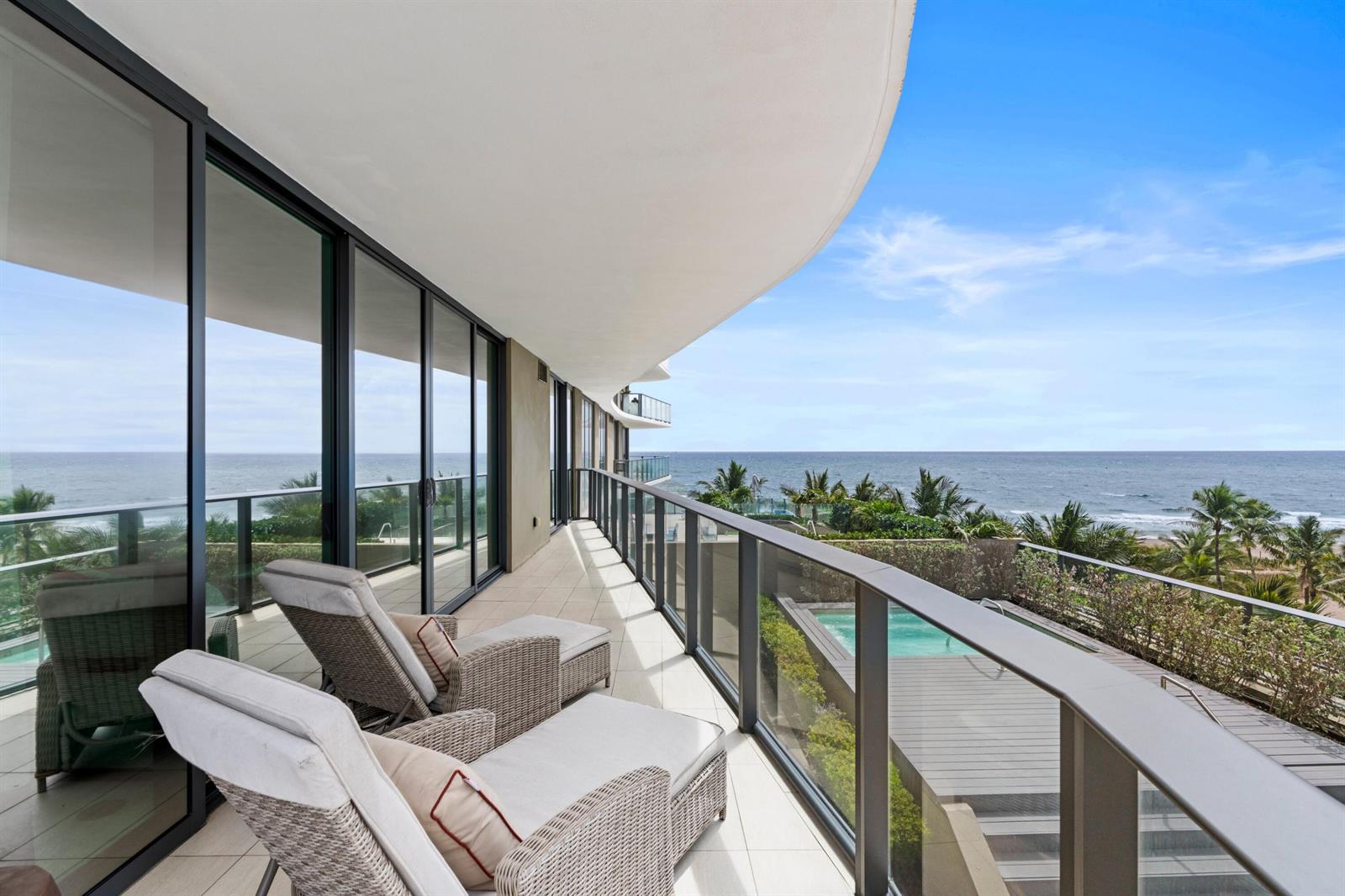 A balcony with lounge chairs overlooks a swimming pool and the ocean — 730 N Ocean Boulevard # 505, Pompano Beach FL 33062, POMPANO BEACH, FL