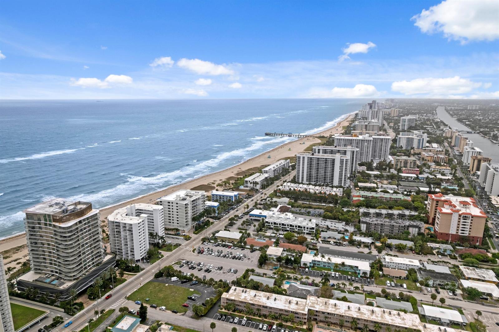 An aerial view shows a coastal city with high-rise buildings, a beach, and the ocean — 730 N Ocean Boulevard # 505, Pompano Beach FL 33062, POMPANO BEACH, FL