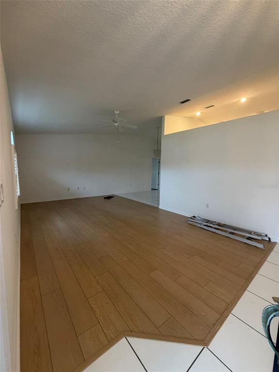 A living room features light wood-look flooring transitioning to white tile near the entrance — 2 LAMAR LANE, PALM COAST, FL