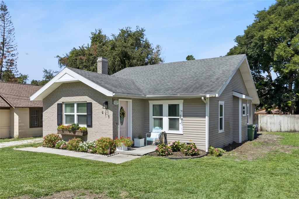 A single-story house with a brick and siding exterior, a front porch, and a grassy yard — 415 8TH STREET NE, WINTER HAVEN, FL