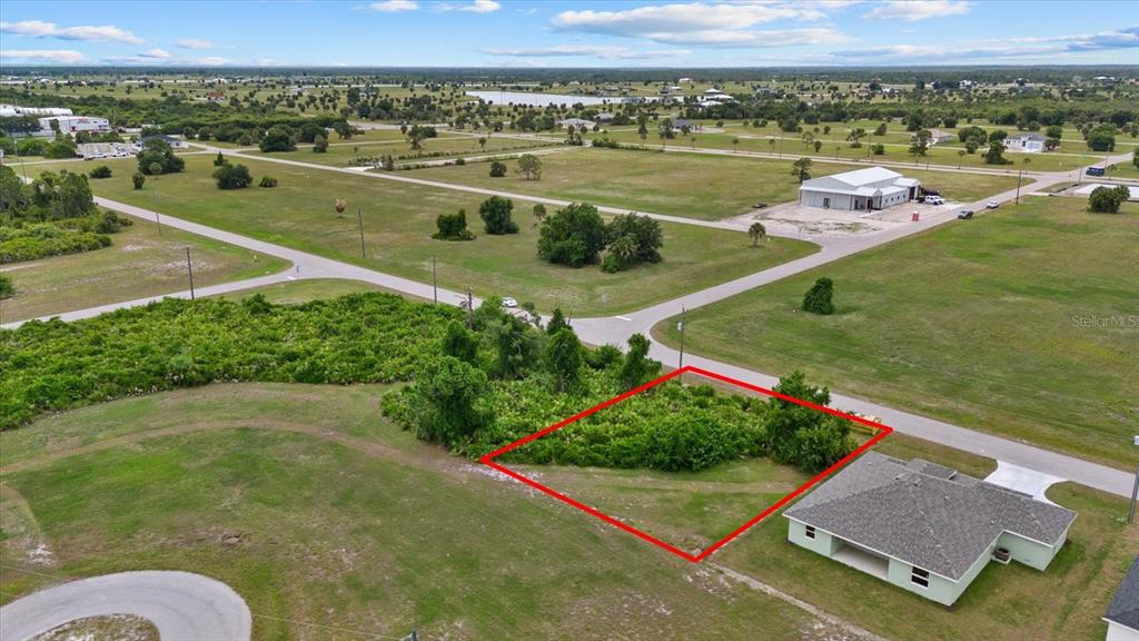 An aerial view shows a vacant, rectangular lot outlined in red next to a house — 66 LATEEN SAIL DRIVE, PLACIDA, FL