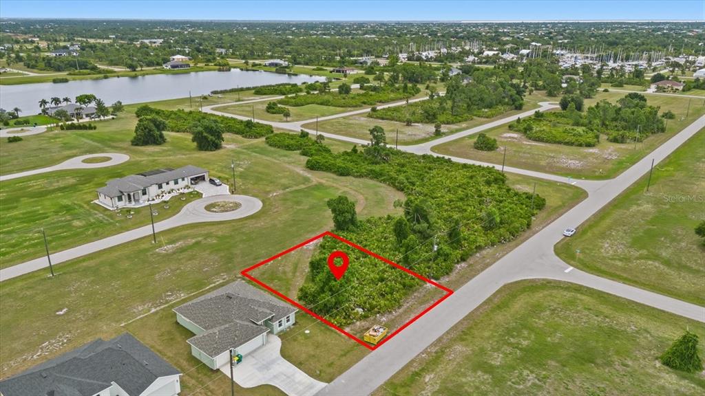 An aerial view shows a vacant, rectangular lot outlined in red next to a house — 66 LATEEN SAIL DRIVE, PLACIDA, FL
