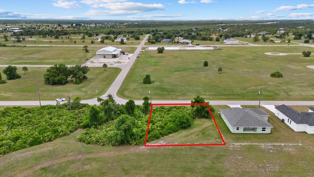 An aerial view shows a vacant rectangular lot outlined in red next to a house — 66 LATEEN SAIL DRIVE, PLACIDA, FL