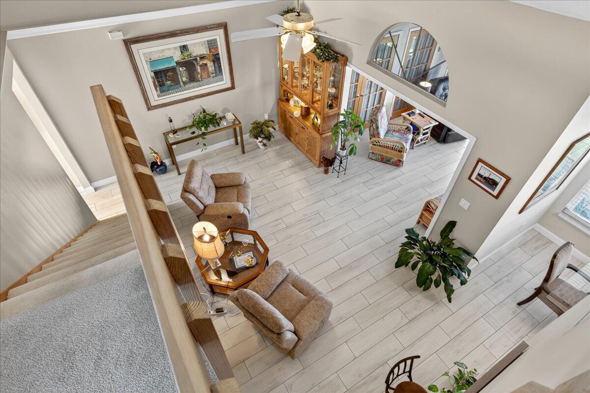 A high-angle view of a living room with light tile flooring, two armchairs, and a hutch — 1827 Aynsley Way # 4, Vero Beach FL 32966, VERO BEACH, FL
