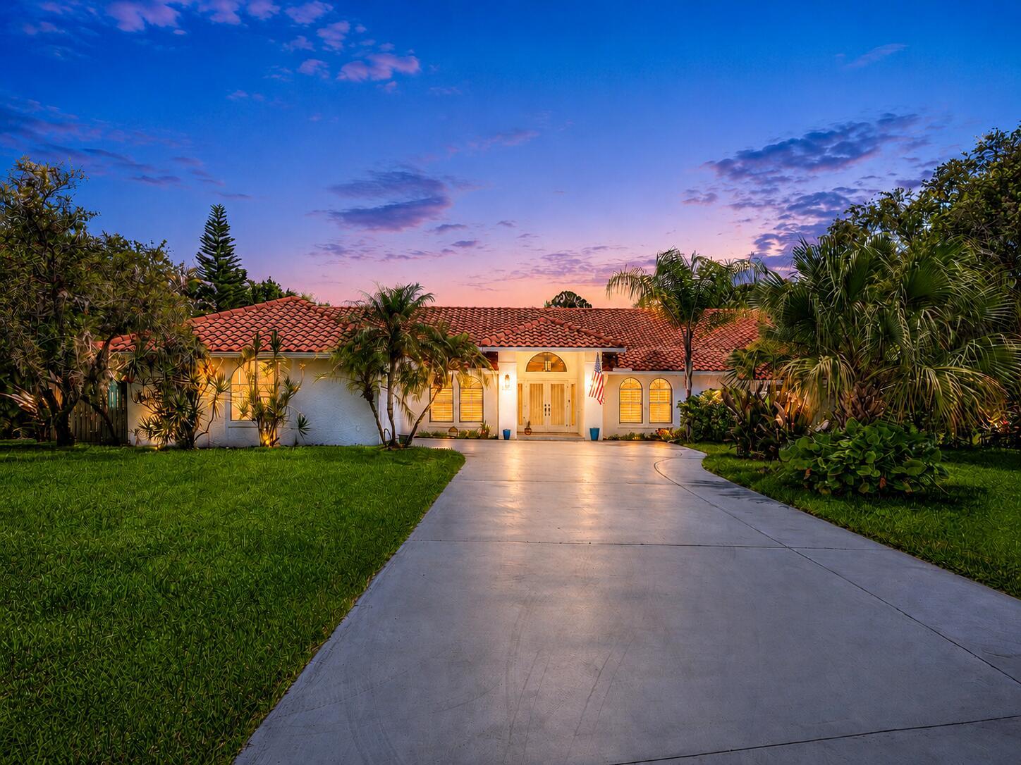 A single-story house with a red tile roof and a concrete driveway at sunset — 1488 SE Colony Way, Jupiter FL 33478, JUPITER, FL