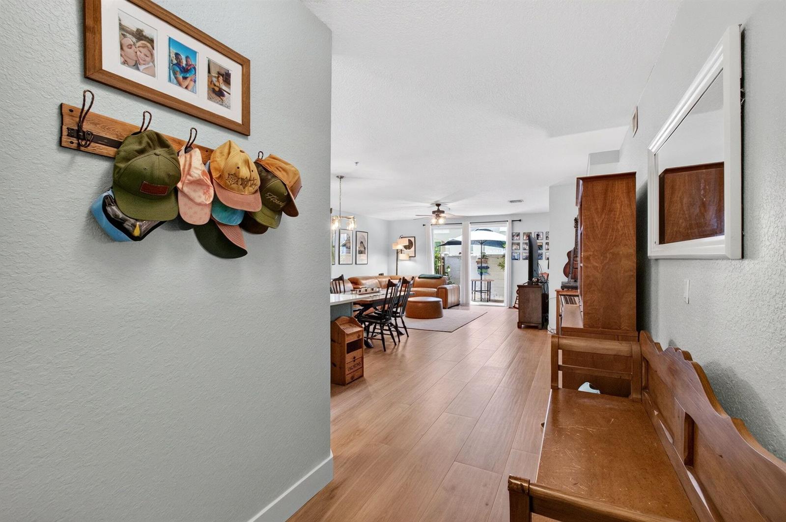 A hallway with a hat rack leads into an open-concept living area with wood flooring — 311 Bayfront Drive, Boynton Beach FL 33435, BOYNTON BEACH, FL