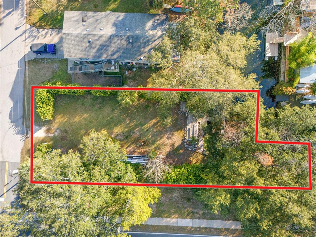 An aerial view shows a rectangular lot with trees, grass, and a small wooden structure — 7287 COVENTRY COURT, WEEKI WACHEE, FL