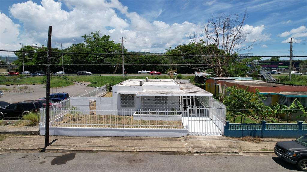 An exterior view of a white, single-story house with a fenced yard and flat roof — 150 ROMAGUERA ST, MAYAGUEZ, PR