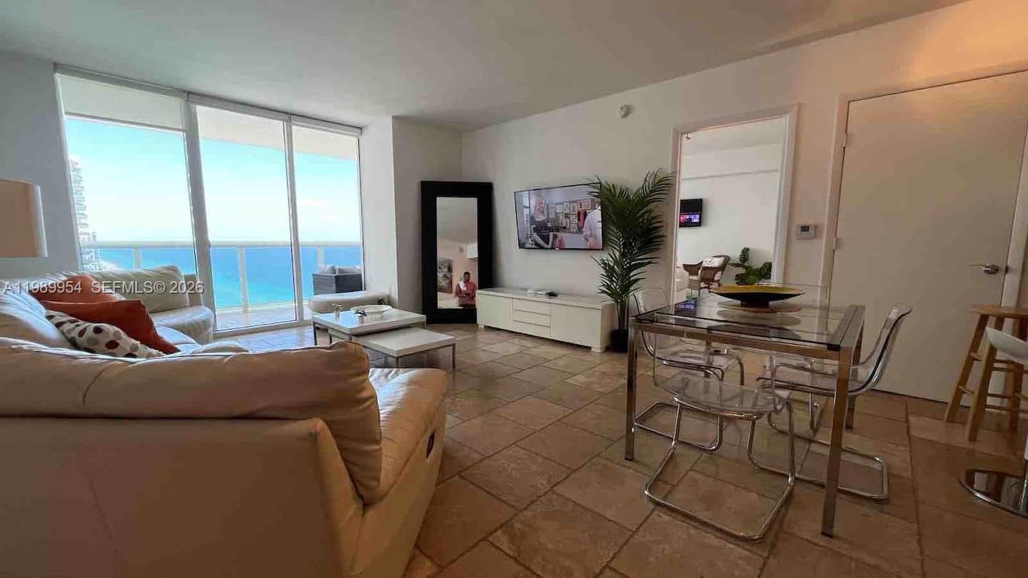 A living and dining area features tile floors, a glass table, and ocean views — 1830 S Ocean Dr # 4010, Hallandale Beach FL 33009, HALLANDALE BEACH, FL