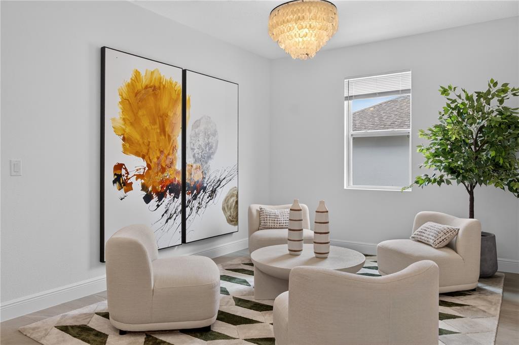 A sitting room features four cream-colored armchairs, a round coffee table, and large abstract art — 2254 LOST HORIZON WAY, MINNEOLA, FL
