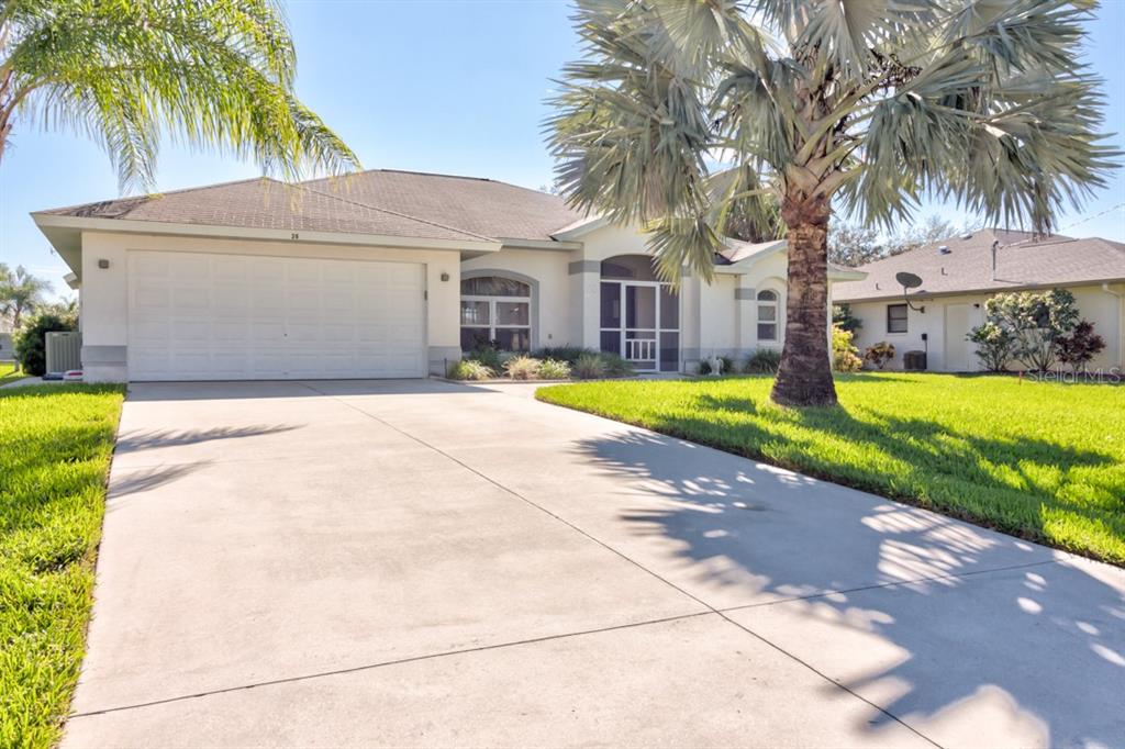 A single-story house with a white garage, a screened entryway, and a large palm tree — 26 LONG MEADOW LANE, ROTONDA WEST, FL