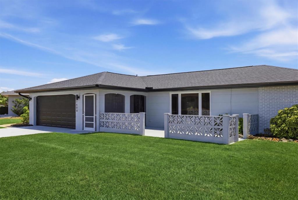 A single-story house with a gray exterior, a garage, and a decorative concrete block wall — 1600 CYPRESS POINT COURT, VENICE, FL