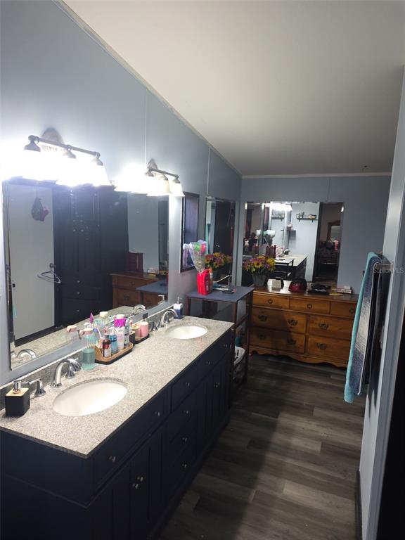 A bathroom features a double vanity with a granite countertop and dark wood cabinets — 3303 TURNBULL ROAD, MIMS, FL
