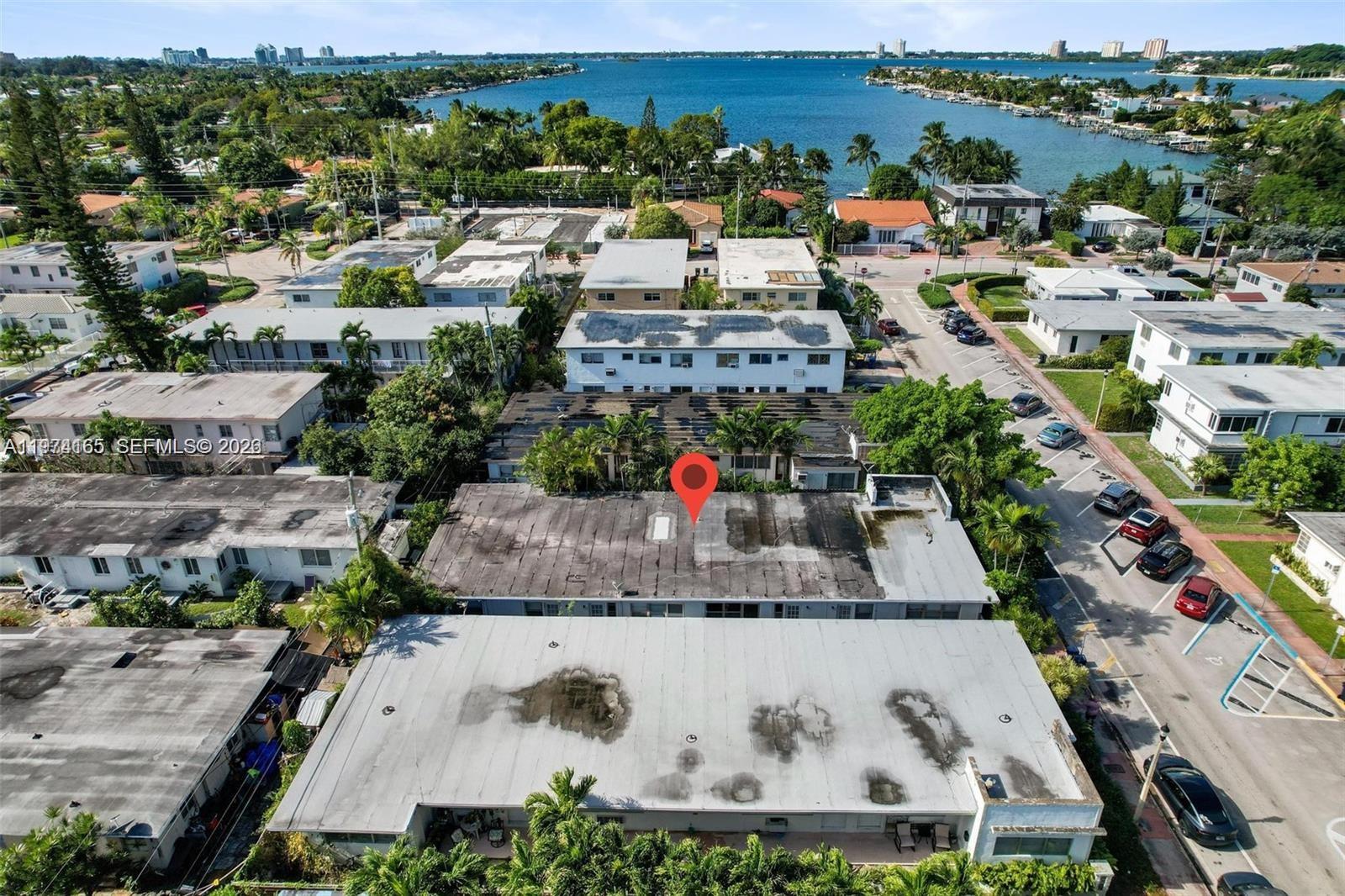 An aerial view shows multiple flat-roofed apartment buildings near a body of water — 810 82nd St, Miami Beach FL 33141, MIAMI BEACH, FL