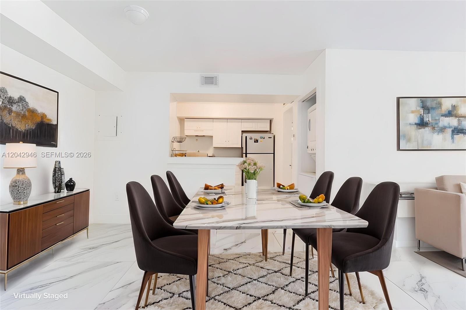 A dining room features a marble-topped table, dark chairs, and a rug on marble flooring — 15241 SW 80th St # 207, Miami FL 33193, MIAMI, FL