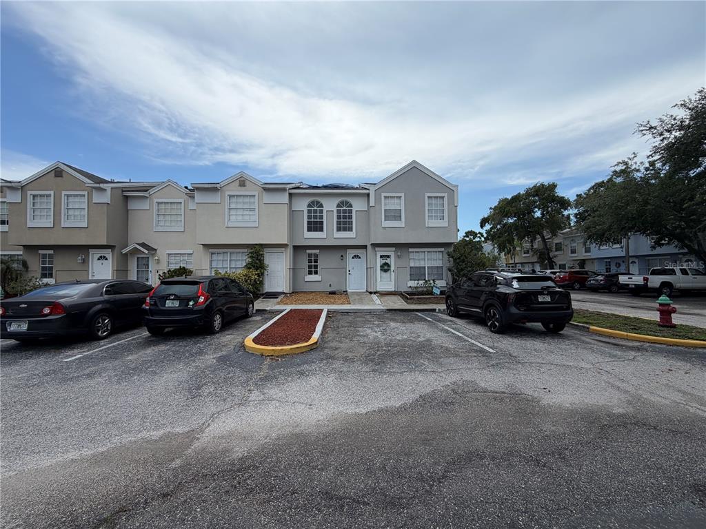 A row of two-story townhomes with parking spaces in front under a cloudy sky — 6661 121ST AVENUE UNIT G, LARGO, FL