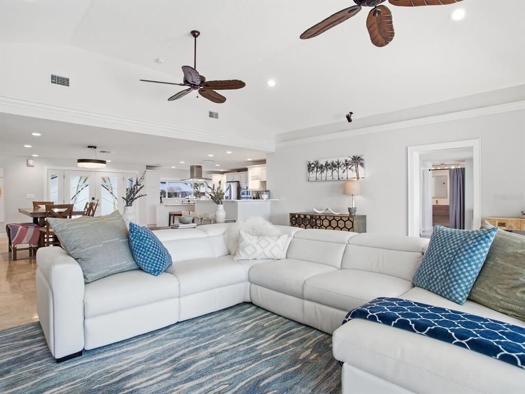 A white sectional sofa sits on a blue patterned rug in a bright open-concept living room — 1028 79TH STREET S, ST PETERSBURG, FL