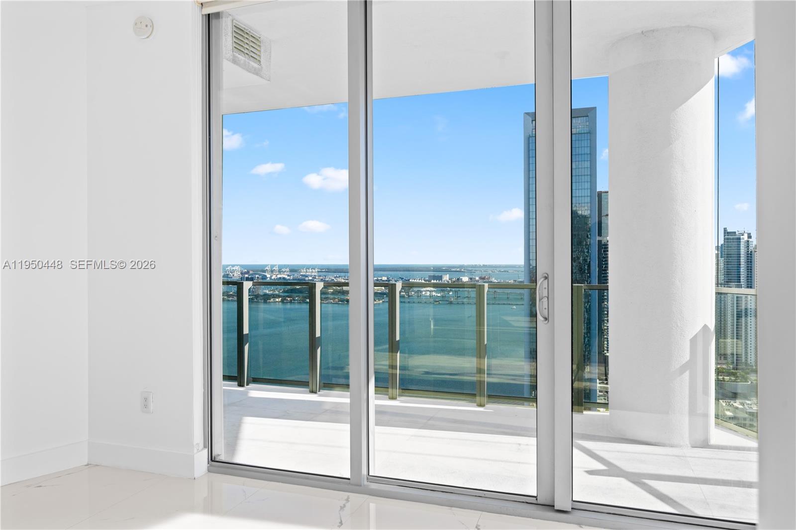 A bright room features floor-to-ceiling sliding glass doors opening onto a balcony with water views — 2900 NE 7th Ave # 4009, Miami FL 33137, MIAMI, FL