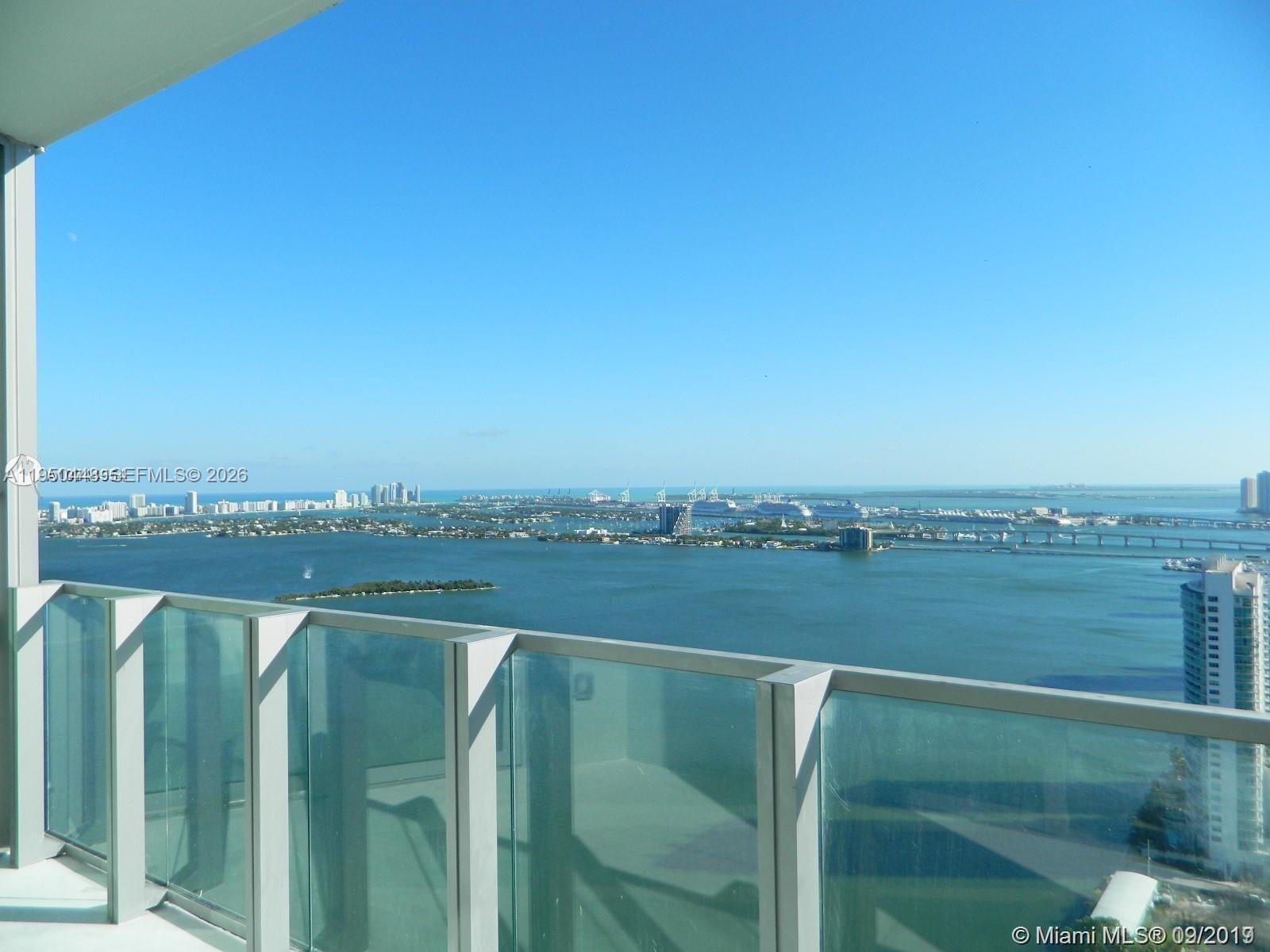 A high-rise balcony overlooks a bay with distant city buildings and cruise ships — 2900 NE 7th Ave # 4009, Miami FL 33137, MIAMI, FL