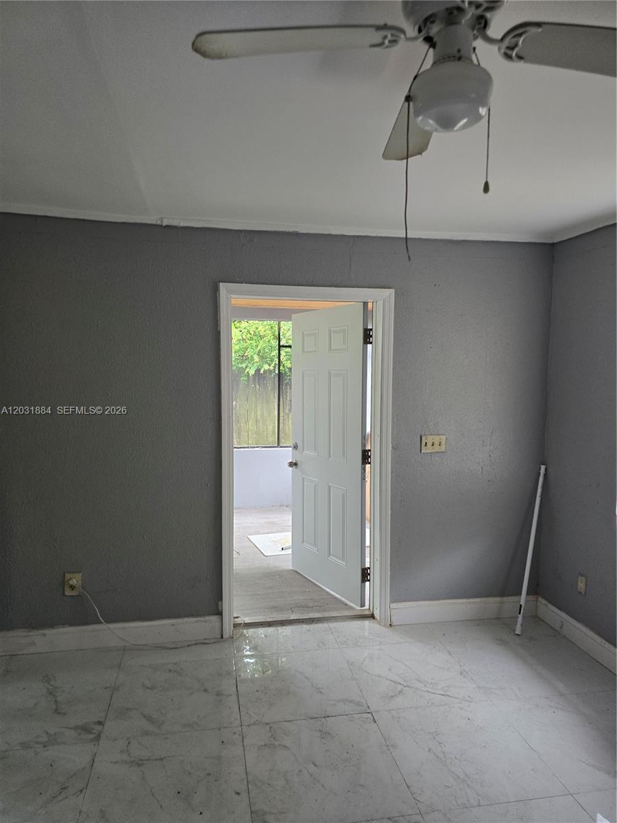 A room with gray walls, white tile flooring, and a ceiling fan leads outdoors — 840 NE 124th St # B, North Miami FL 33161, NORTH MIAMI, FL