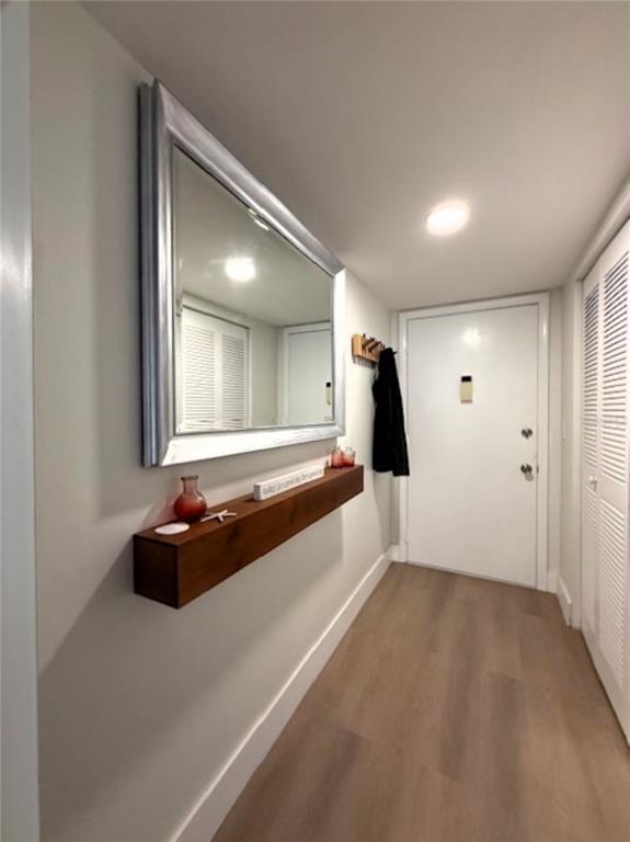 A hallway features a floating wooden shelf, a large silver-framed mirror, and light wood flooring — 3806 GULF OF MEXICO DRIVE UNIT C305, LONGBOAT KEY, FL