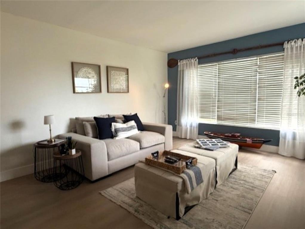 A living room features a beige sofa, a dual-ottoman coffee table, and a blue accent wall — 3806 GULF OF MEXICO DRIVE UNIT C305, LONGBOAT KEY, FL
