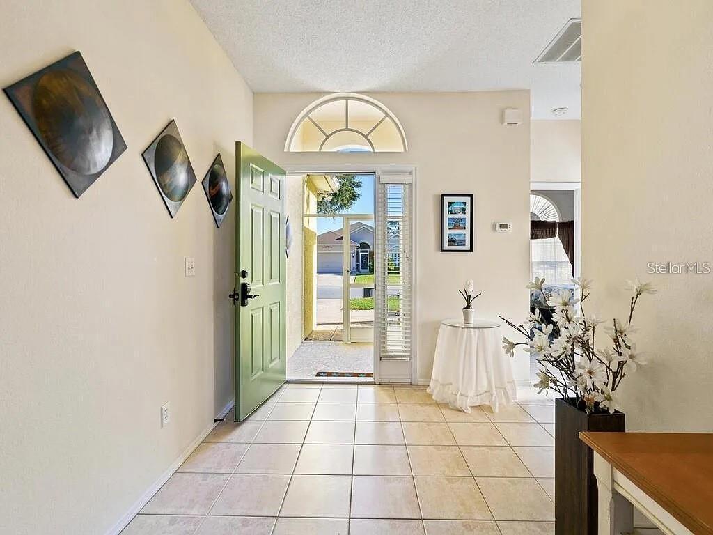 An entryway with tiled floors, a light green front door, and a screen-enclosed porch — 5044 45TH STREET W, BRADENTON, FL