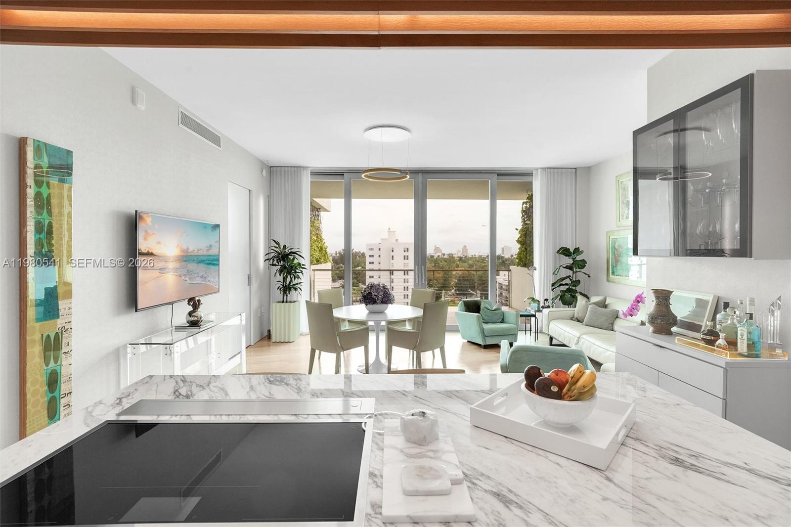 A modern living and dining area features marble countertops, floor-to-ceiling windows, and city views — 1300 Monad Ter # 7C, Miami Beach FL 33139, MIAMI BEACH, FL
