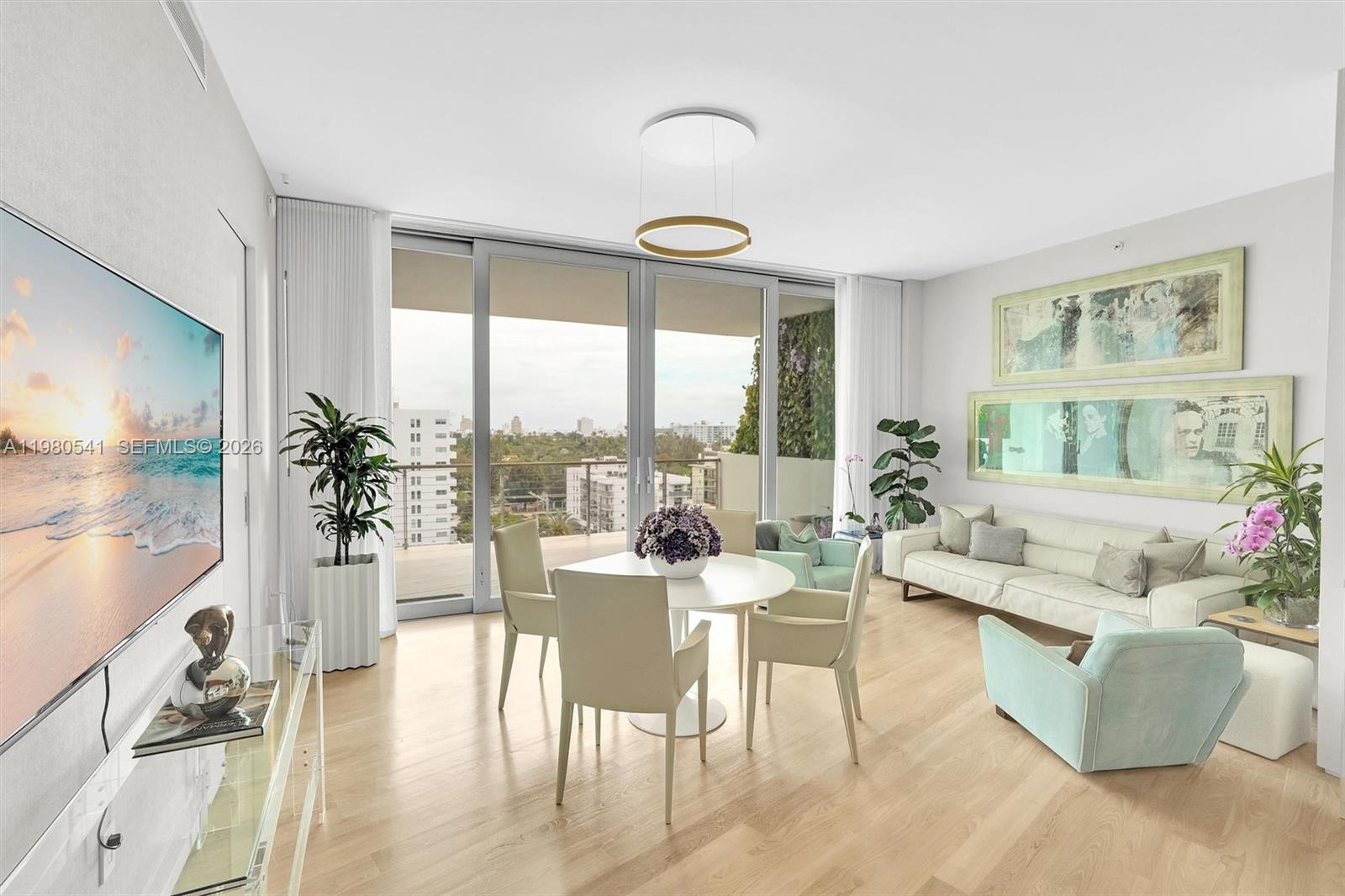 A bright living and dining area features light wood floors, floor-to-ceiling windows, and modern furniture — 1300 Monad Ter # 7C, Miami Beach FL 33139, MIAMI BEACH, FL